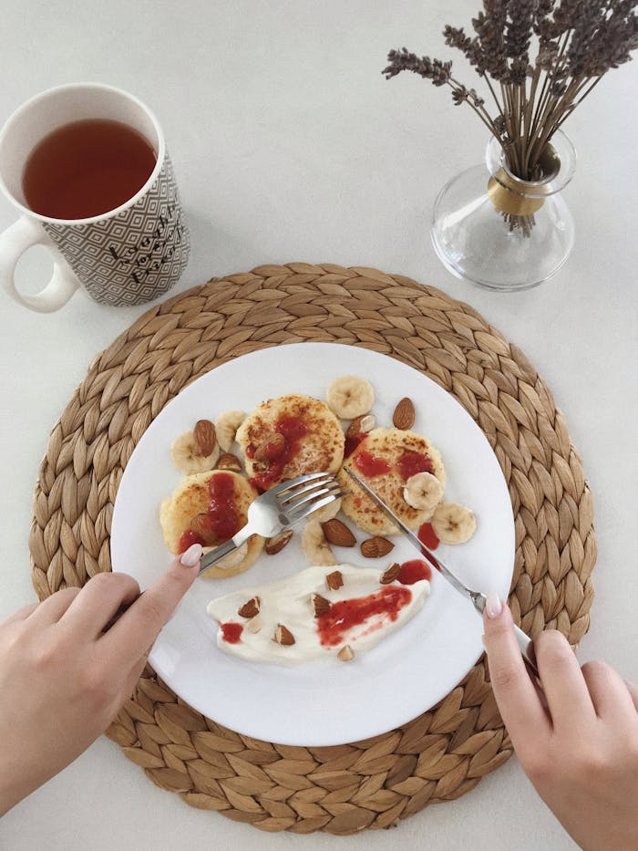 Services Delicious homemade pancakes with banana and almonds, served with tea.